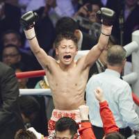 Top of the world: Naoya Inoue raises his arms in triumph after winning the WBC light flyweight world title. | KYODO