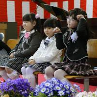 Four new first-graders attend the entrance ceremony at Furumachi Elementary School in the city of Tamura, Fukushima Prefecture, on Monday. The evacuation order for the Miyakoji district of Tamura was lifted on April 1 for the first time since the nuclear disaster began unfolding at the Fukushima No. 1 nuclear power plant in March 2011. | KYODO