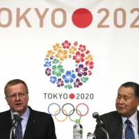 International Olympic Committee Vice President John Coates delivers a speech as Yoshiro Mori, president of the organizing committee for the 2020 Tokyo Olympic and Paralympic Games, listens at a press conference in Tokyo on Friday. IOC officials praise Tokyo's initial preparations for 2020 Olympics
