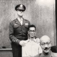 Slap happy: Shumei Okawa (center) is restrained  after slapping former Prime Minister Hideki Tojo (front) on the head on May 3, 1946, at the International Military Tribunal for the Far East. | www.britishpathe.com