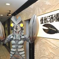 Alien Baltan, proprietor of Kaiju Sakaba, a restaurant-bar in Kawasaki, stands at the entrance on March 13 ahead of its official opening. According to the management, Alien Baltan “hides himself from human beings” during business hours. Tokyo jumps on theme bar bandwagon