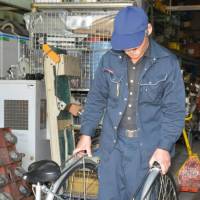 The frame of the wheelchair is created by loosening a screw underneath the saddle and swinging the front wheel around until it is facing the back wheel.  | CHUNICHI SHIMBUN