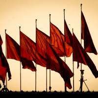 Members of China\'s paramilitary force (bottom left) monitor Tiananmen Square with surveillance equipment before the closing session of the National People\'s Congress, the country\'s national legislature, in the Great Hall of the People in Beijing on March 14. | AP