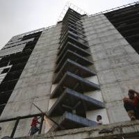 The 45-story \"Tower of David,\" seen Feb. 3 from the 30th floor, was intended to be a shining new financial center in the heart of Caracas but it was abandoned in 1994 after the developer\'s death. Squatters in 2007 invaded the huge concrete skeleton, turning it into the highest slum in the world. It now houses 3,000 people. | REUTERS