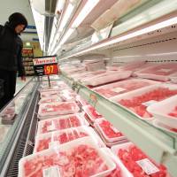 A shopper looks at packaged U.S. beef at a Seiyu GK supermarket in Tokyo last year. U.S. beef exporters disadvantaged by Aussie-Japan free trade pact