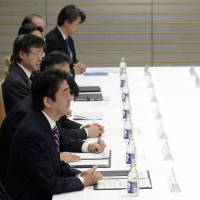 Prime Minister Shinzo Abe (left) listens as U.S. House Majority Leader Eric Cantor delivers an opening address at the start of their meeting with a delegation of U.S. representatives Monday at the Prime Minister\'s Official Residence in Tokyo. | REUTERS/POOL