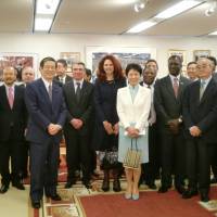 Saudi Arabian Ambassador Abdulaziz Turkistani presents a bouquet to Princess Takamado in gratitude of her contribution to the annual photo exhibition \"Japan through Diplomats\' Eyes\" during an event held on April 23 at the Saudi Arabian Embassy in Tokyo to promote the exhibition, attended by more than 50 ambassadors | CHIHO IUCHI