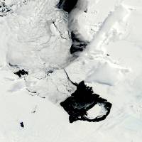 These photos taken Dec. 10 (left) and March 11 by NASA show a large iceberg separating from the Pine Island Glacier and traveling across Pine Island Bay in Antarctica. Scientists are watching the iceberg, which is bigger than the island of Guam, as it slowly moves away from the glacier (bottom right in December, upper left center in March). | AP