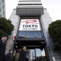 Pedestrians walk past the Tokyo Stock Exchange run by Japan Exchange Group Inc. in January 2013. | BLOOMBERG