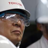 Mitsuru Kawai, senior technical executive of Toyota Motor Corp., looks at workers in the forging department at one of the company\'s plants in Toyota, Aichi Prefecture, in February. | BLOOMBERG