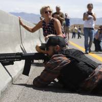 A protester aims his weapon from a bridge next to the Bureau of Land Management\'s camp, where seized cattle belonging to rancher Cliven Bundy were being held in Bunkerville, Nevada, on April 12. | REUTERS
