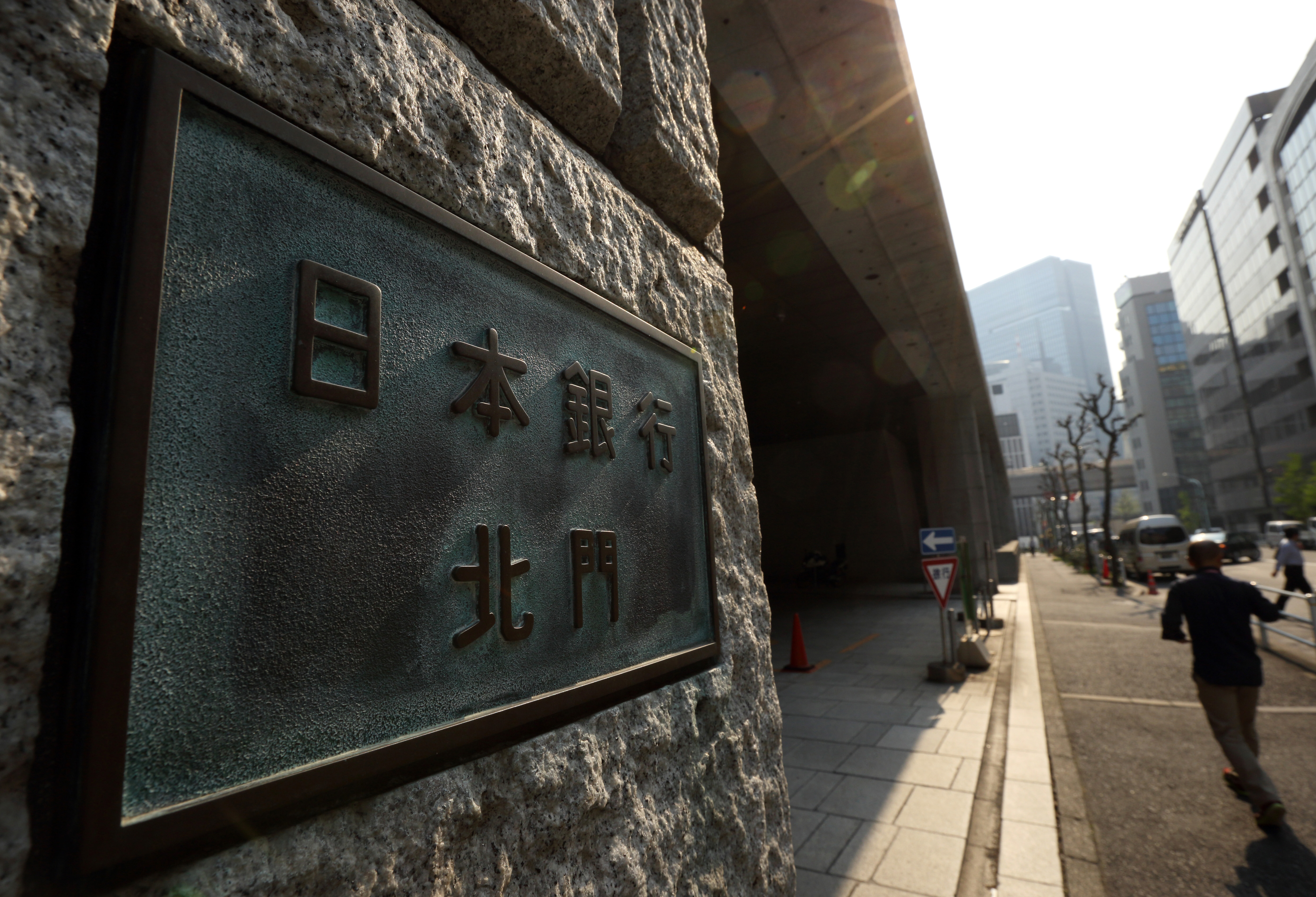 People walk past the entrance to the headquarters of the Bank of Japan in Chuo Ward, Tokyo, on April 8. | BLOOMBERG