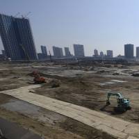 Excavators operate at a construction site in the Toyosu area of Tokyo in March. | BLOOMBERG
