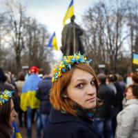 A woman wearing a flower crown looks back during a pro-Ukrainian rally in the eastern city of Luhansk on Tuesday. | AFP-JIJI