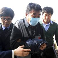 Lee Joon-seok (center) the captain of the sunken ferry Sewol, arrives at the headquarters of a joint investigation team of prosecutors and police in Mokpo, South Korea, on Saturday. | AP