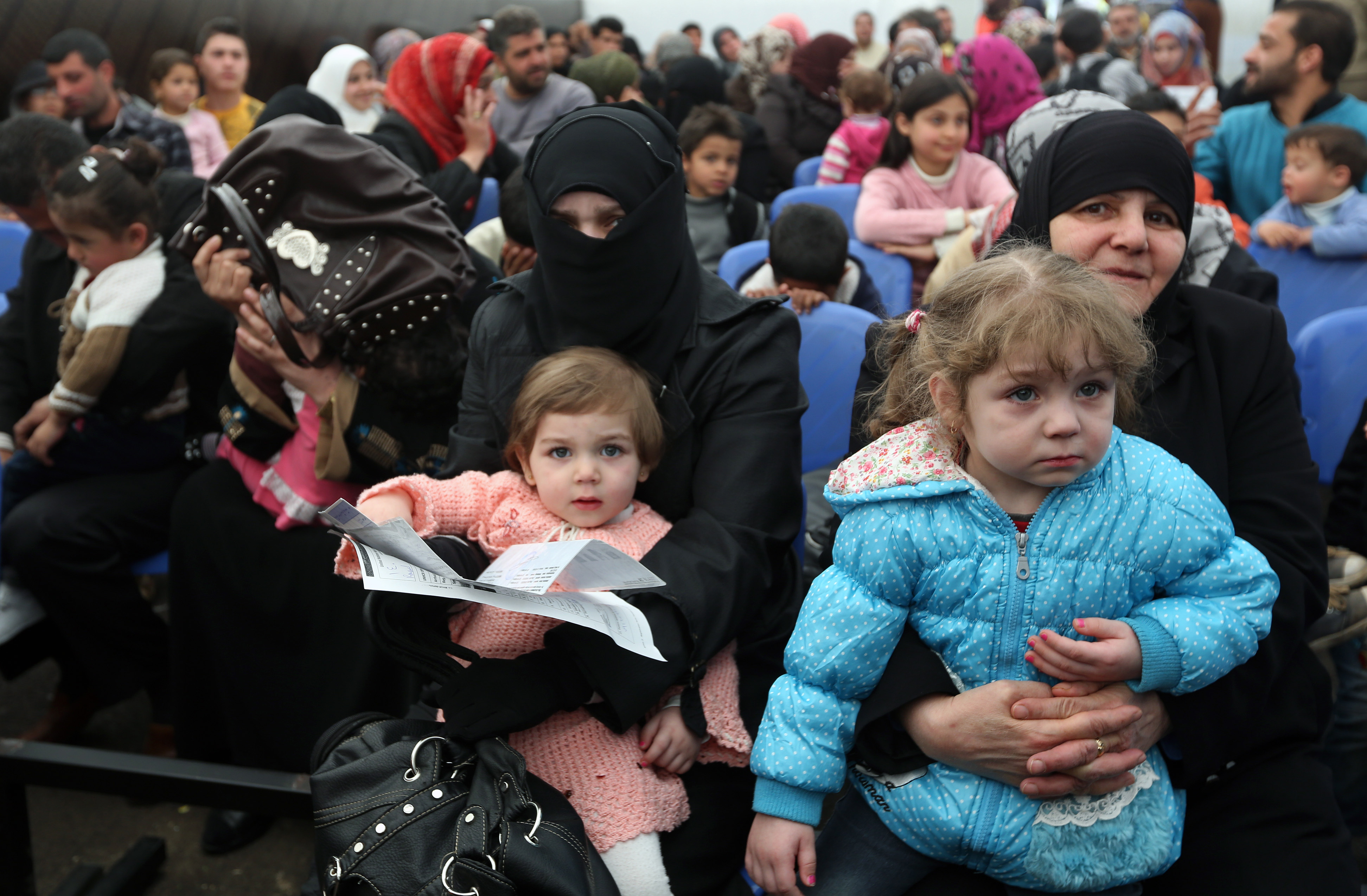 Syrian families await their turn to register at the United Nations High Commissioner for Refugees center in Tripoli on Thursday. | AP