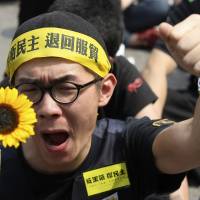 A demonstrator shouts slogans in front of the Presidential Office in Taipei on March 30. Thousands of demonstrators have marched the streets in recent weeks to protest a controversial trade pact with mainland China &#8212; a deal that opposition leaders say will disadvantage Taiwan and leave it vulnerable to Chinese encroachment. | REUTERS