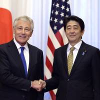 U.S. Secretary of Defense Chuck Hagel shakes hands with Prime Minister Shinzo Abe in Tokyo on Saturday. | POOL/AP