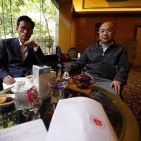 A paper with the verdict in the trial of Chinese rights activist Xu Zhiyong is seen on a table as Xu\'s lawyers Zhang Qingfang (right) and Liu Shuqing speak to journalists at a hotel in Beijing on Friday. The prominent Chinese rights activist expressed defiance Friday after a court upheld his four-year jail sentence, saying the pall of communism and dictatorship would eventually give way to freedom and justice. | REUTERS