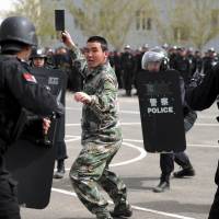 Riot police carry out a drill in Urumqi, the capital of China\'s Xinjiang region, on Saturday, ahead of a visit by President Xi Jinping. | REUTERS