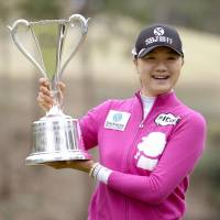 Weekend joy: Esther Lee holds the Studio Alice Ladies Open winner\'s trophy on Sunday in Miki, Hyogo Prefecture. | KYODO