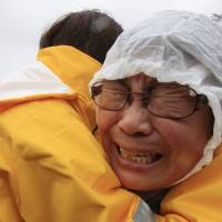 A relative of a passenger aboard the sunken ferry Sewol weeps at a port in Jindo, South Korea, on Thursday. | AP