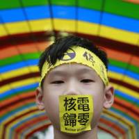 A boy takes part in an anti-nuclear sit-in outside the presidential office in Taipei on Saturday. Hundreds of activists attended the event to demand the government halt construction of a controversial new nuclear power plant. | REUTERS