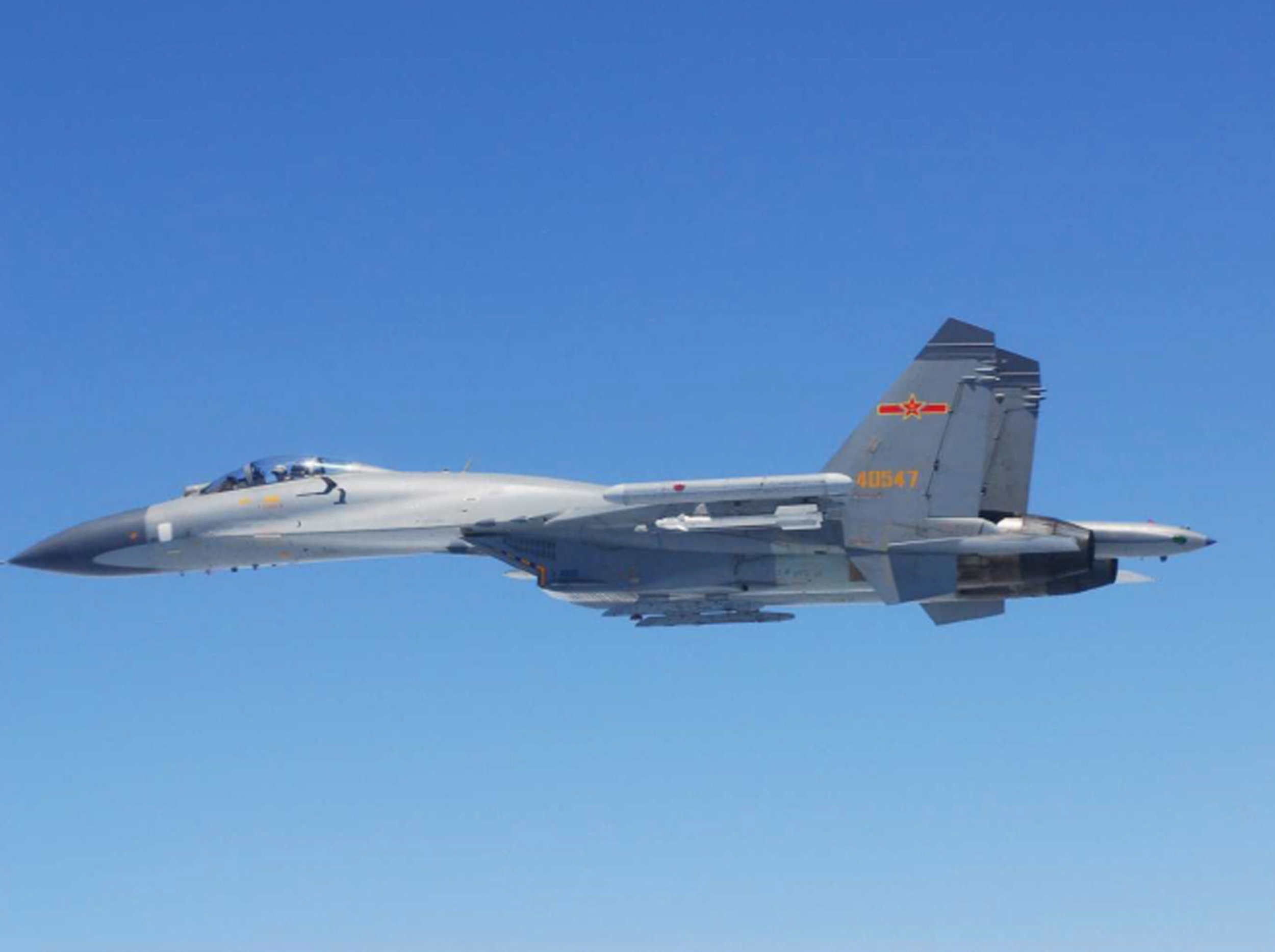 A Chinese SU-27 fighter flies over the East China Sea on Saturday. Chinese fighter jets reportedly came as close as 30 meters to Japanese surveillance planes near the Senkaku Islands, officials said Sunday, prompting the defense minister to accuse Beijing of going 'over the top' in response to sovereignty rows. | DEFENSE MINISTRY/REUTERS