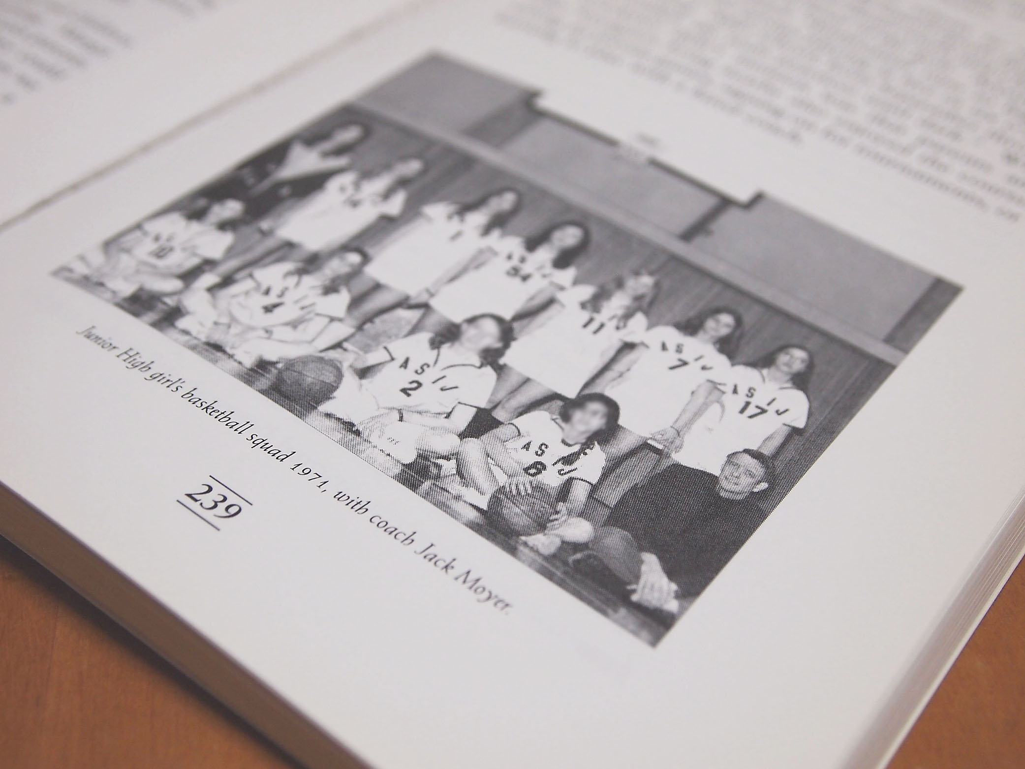 Dark history: One of the remaining copies of “The American School in Japan: A History of Our First Century” shows teacher Jack Moyer with the girls’ basketball team he coached in 1971. Copies of the book were destroyed after Janet Simmons, a former ASIJ student who was abused by Moyer in the early 1970s, confronted staff about the book, which praises Moyer. | JON MITCHELL