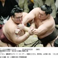 Back in the top spot: Yokozuna Hakuho outmuscles Kisenosato on Thursday to improve to 11-1 and regain the lead at the Summer Grand Sumo Tournament. | KYODO