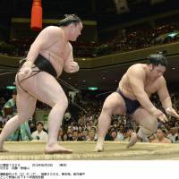 All in a day\'s work: Hakuho defeats sekiwake Tochiozan (right) in their Tuesday match at the Summer Grand Sumo Tournament. | KYODO