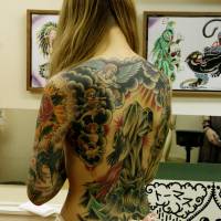 A woman shows a tattoo designed by Inkrat in Koenji, Tokyo. Inkrat caters to clientele who prefer the aesthetic of classic Americana-style tattoos. | MANAMI OKAZAKI