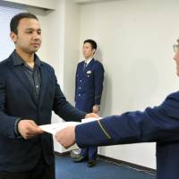 Anuj Raj Karki, a Nepalese resident of Tokyo, receives a letter of appreciation Friday at Kojimachi Police Station in Chiyoda Ward, Tokyo, for rescuing a woman who was nearly run over by a train earlier this month. | KYODO