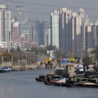 Barges filled with construction materials are docked at Suzhou Creek in Shanghai. | BLOOMBERG