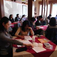 Attendants browse handouts on the Constitution during a \"Constitution cafe\" session at a restaurant in Zama, Kanagawa Prefecture, on April 17. The events held by lawyer Keiko Ota are raising general interest in constitutional issues. | MIZUHO AOKI