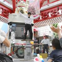 Kenta, a member of a traveling circus troupe led by Keiichi Nishida, performs in a shopping arcade in Nagoya on May 9. | CHUNICHI SHIMBUN