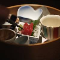 A chef places wasabi next to slices of tuna sashimi at a Japanese restaurant in Tokyo on Dec. 5. Michelin-starred chef fears loss of tradition