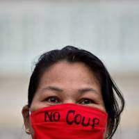 A woman takes part in a demonstration at the Victory Monument in central Bangkok on Tuesday, five days after the military seized power in a coup. | AFP-JIJI