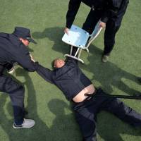 Policemen take part in counterterrorism training in Shijiazhuang, China, on Tuesday. Six people were wounded in a knife attack at a Chinese train station the same day, one of a spate of recent stabbings that have rocked the nation. | AFP-JIJI