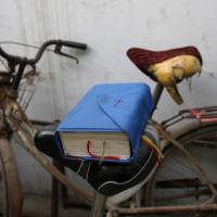 A Bible balances on a bicycle saddle outside an underground Catholic church in the northern Chinese city of Tianjin on Nov. 10. | REUTERS