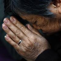 A woman prays during a weekend Mass at the church, which is barely tolerated by the Communist Party. | REUTERS