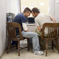 Two gay men hold their heads together as they apply for a marriage certificate at Philadelphia\'s City Hall on May 21. | AP