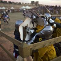 Fighters from Germany (in yellow vests) and the United States (in dark colors) compete in the Medieval Combat World Championship tournament in Belmonte, Spain, on May 1. | AP