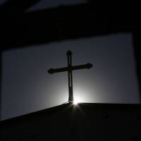 A cross is silhouetted at an underground Catholic church in Tianjin, China, a testament to the ability of Catholicism to survive outside the Communist Party\'s reach. | REUTERS