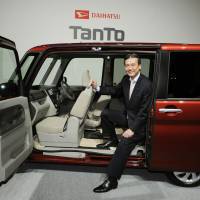 Daihatsu Motor Co. President Masanori Mitsui shows off an updated version of the Tanto minicar in Tokyo in October. | KYODO