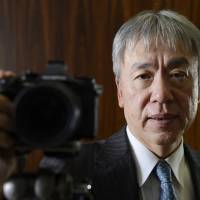 Hiroyuki Sasa, president and chief executive officer of Olympus Corp., shows off the company\'s OM-D E-M1 Micro Four Thirds camera during an interview in Tokyo. | BLOOMBERG