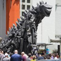 A 6-meter-tall statue of Godzilla towers over visitors after it was unveiled in front of the TCL Chinese Theatre in Hollywood, California, on May 9, ahead of the release of the latest Hollywood reboot of the classic monster movie. Monster hits continue to survive the Internet age