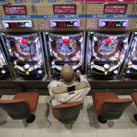 A visitor plays Pachinko at a Dynam Japan Holdings Co. pachinko parlor in Koga, Ibaraki Prefecture, last month. Pachinko parlors face taxing times