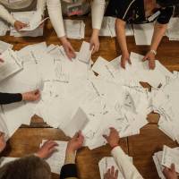 Members of an election committee count ballots after voting closed at a polling station in Donetsk, Ukraine, on Sunday. Voters in two rebel Ukrainian regions cast ballots Sunday on whether to declare their areas sovereign republics, a move denounced by the central government and likely to deepen the turmoil in the largely Russian-speaking east. | AP