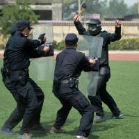 Policemen take part in counterterrorism training in Shijiazhuang, northern China, on Tuesday after six people were wounded in a knife attack at a Chinese train station. | AFP-JIJI